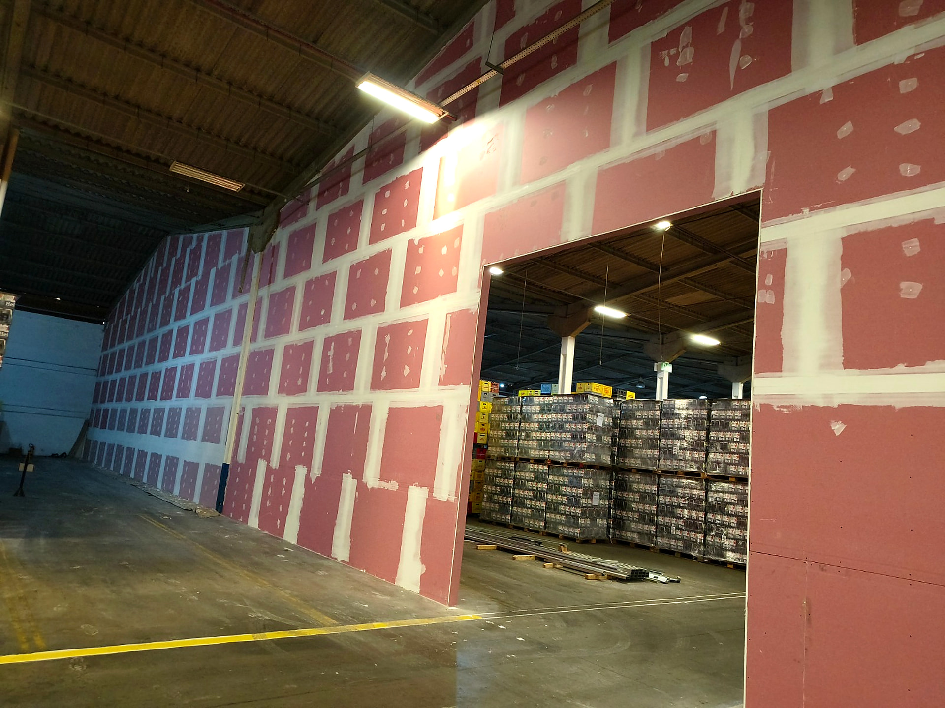 Parede de drywall finalizada com tratamento de juntas em galpão